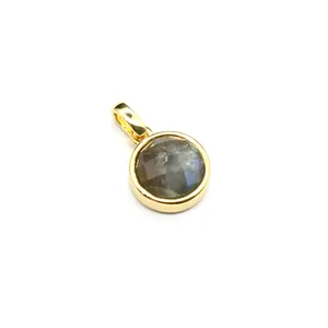 Close-up of a small faceted natural stone pendant with a round gold-plated bezel