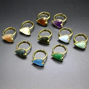 Close-up of vintage heart-shaped rings with colorful natural stones and gold adjustable bands