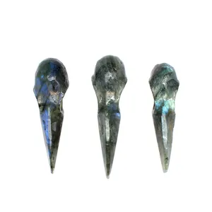 Group of three hand-carved natural labradorite raven skull pendants with vibrant blue flashes.