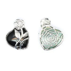 Détail de pendentifs cœur en pierre naturelle avec motifs roses argentées en noir et vert