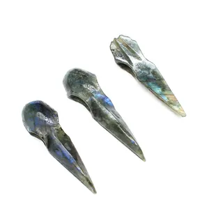 Detail view of three natural labradorite raven skull pendants with blue iridescent flashes