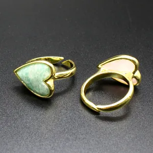 Close-up of vintage gold adjustable rings featuring green and pink heart-shaped stones.