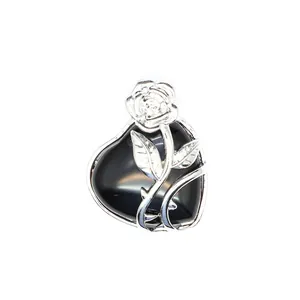 Vue détaillée d'un pendentif cœur en rose argenté avec pierre noire polie