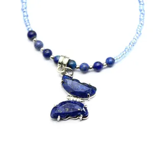 Detail of a blue lapis lazuli butterfly pendant necklace with elegant beaded chain.