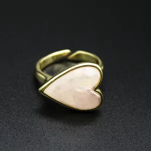 Close-up detail of a vintage gold heart ring with an elegant pink natural stone inlay