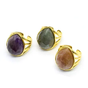 Macro view of pear-cut crystal rings in gold plating with faceted colorful stones