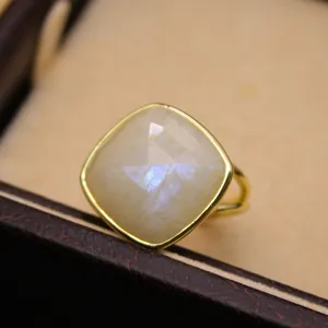 Primer plano de un anillo de piedra de luna natural con una montura dorada ajustable