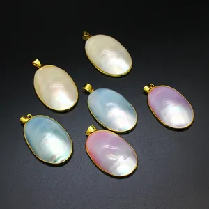 Close-up of colorful oval natural mother of pearl pendants with gold plated edges.