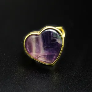 Detalle macro de un anillo de piedra natural púrpura en forma de corazón dorado