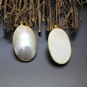Detailed view of two oval natural mother-of-pearl shell pendants with elegant gold plating