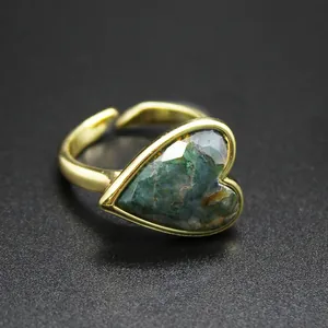 Detailed macro view of vintage heart-shaped ring featuring a green natural moss agate stone