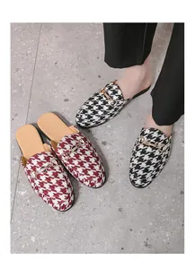 Detailed view of stylish houndstooth pattern mules featuring a horsebit metal buckle