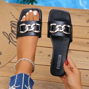 Stylish black flat slide sandals with a gold chain buckle and elegant square toe