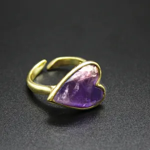 Macro detail of a vintage heart ring featuring a purple natural stone on gold band