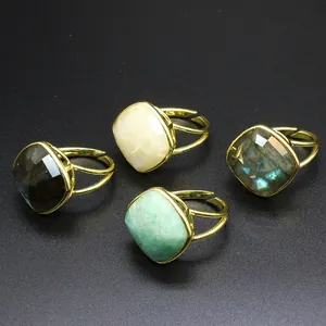 Vista detallada de varios anillos de piedra natural con bandas doradas ajustables