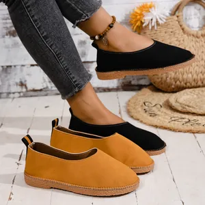 Macro view of vintage soft upper women's flat shoes in black and yellow colors on wooden floor