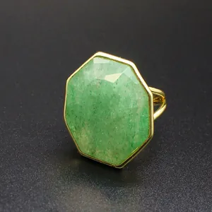 Gros plan d'une grande bague d'apparat en pierre naturelle verte octogonale dorée