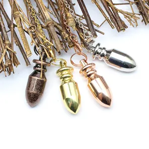 Primo piano di quattro pendoli conici in ottone in oro, argento, oro rosa e bronzo.