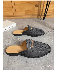 High-quality detail of men's quilted black backless loafers with golden metal bit