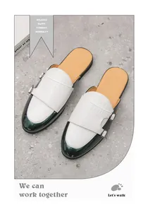 Primer plano de elegantes zuecos para hombre en cuero con relieve de cocodrilo blanco y verde