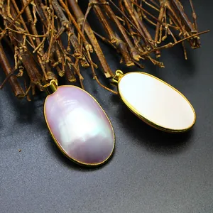 Macro detailed view of oval natural shell pendants with shiny golden finish bail design