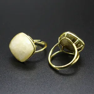 Detalle de anillo de piedra lunar con piedra facetada y banda dorada