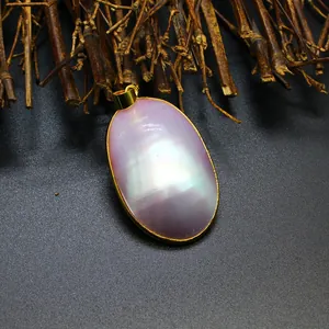 Macro view of natural iridescent pink mother of pearl pendant with gold frame