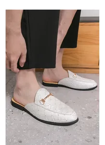 Detail of white men's British style mules with gold buckle and lattice pattern.