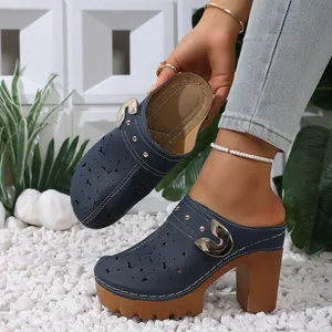 Detailed macro view of navy blue laser-cut mules featuring decorative gold buckle and chunky heel
