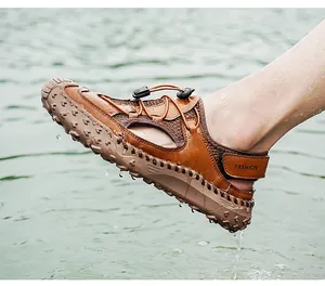 Macro view of breathable men's brown leather outdoor sandals dripping water in a lake