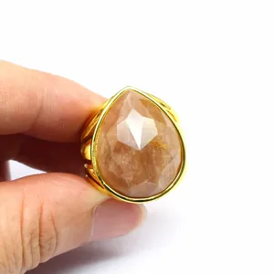 Large teardrop faceted crystal ring in gold finish held by hand