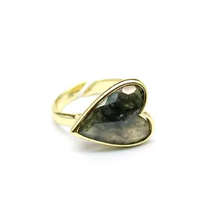 Close-up of a vintage gold heart ring with a dark grey faceted natural stone detail