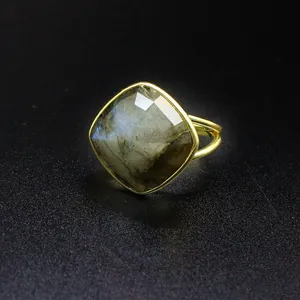 Primer plano de anillo de piedra de luna natural facetada con banda dorada ajustable