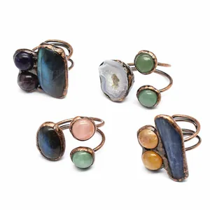 Detail showing four copper wire wrapped rings with various natural raw crystals