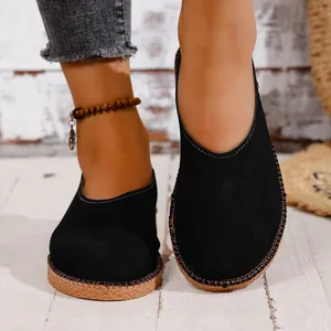 Detailed view of women's black retro round-toe slip-on flat shoes with textured gum sole