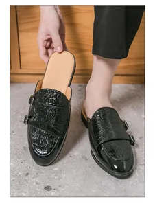 Detalle de mocasines abiertos de cuero negro para hombre con patrón de cocodrilo