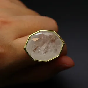 Vue détaillée d'une grande bague en quartz naturel facetté avec un cadre doré.