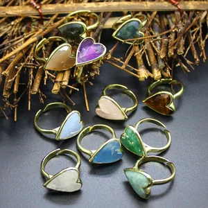 Detail view of colorful heart-shaped natural stone rings with gold adjustable bands