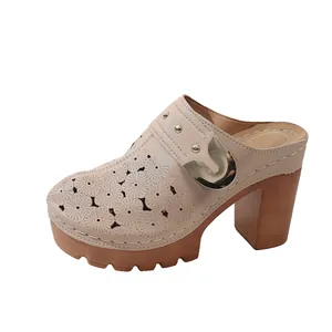 Detailed close-up of women's beige laser-cut platform mules with gold metal buckle