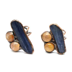 Detail view of a handmade raw blue kyanite and orange agate stone ring in copper setting.