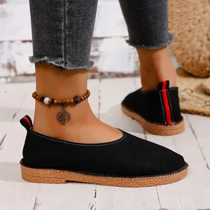 Close-up of black retro round toe slip-on ballet flats with textured gum sole