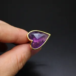 Detailed close-up of a vintage heart-shaped purple gemstone ring with gold plating