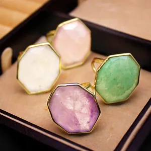 Vue détaillée de bagues octogonales en pierre naturelle colorée dans une boîte cadeau.