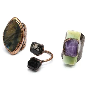 Macro detail of vintage raw stone rings with amethyst and labradorite in antique copper