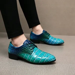Nahaufnahme der spitzen Herrenlederschuhe mit blau-grünem Farbverlauf und Krokoprägung