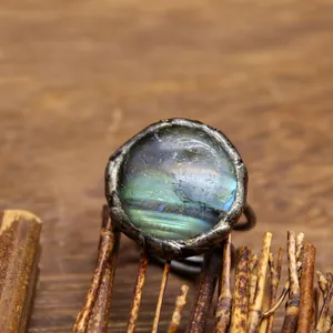 Dettaglio di un anello vintage in argento ossidato con una pietra tonda di labradorite iridata