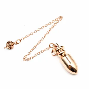 Dettaglio di un pendolo conico in ottone oro rosa lucido con una catena a maglie fini.