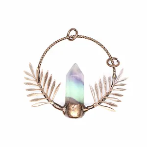 Detailed view of the natural fluorite crystal point and antique bronze leaf pendant detail.