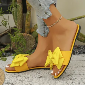 Eleganti sandali bassi gialli da donna con grande fiocco decorativo e design casual