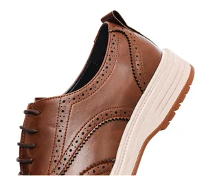 Detailed macro shot of brown leather brogue shoes featuring classic decorative perforations
